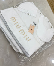 Miu Miu infant set features a branded embroidered blanket, bib, and cap