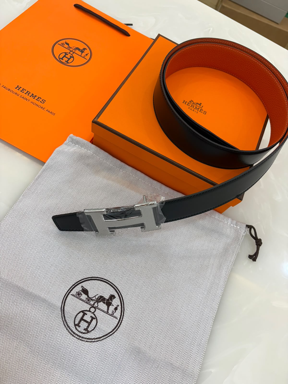 Reversible leather "H" buckle and a black and orange strap