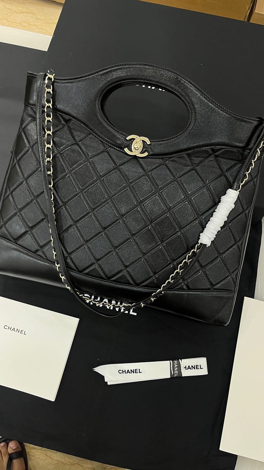 Black quilted tote is a Chanel 31 shopping bag